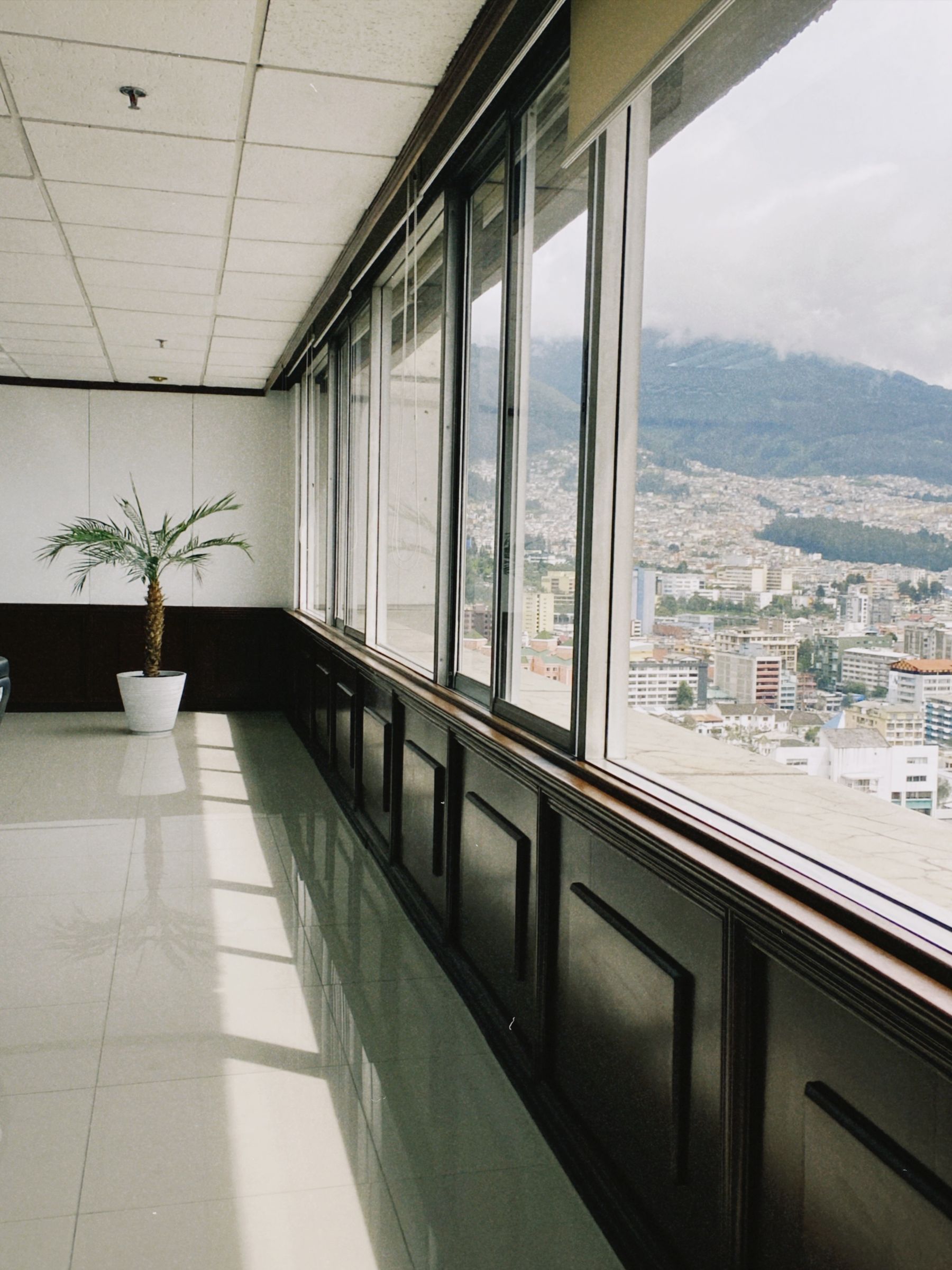 A modern executive interior with a wall of windows overlooking the city