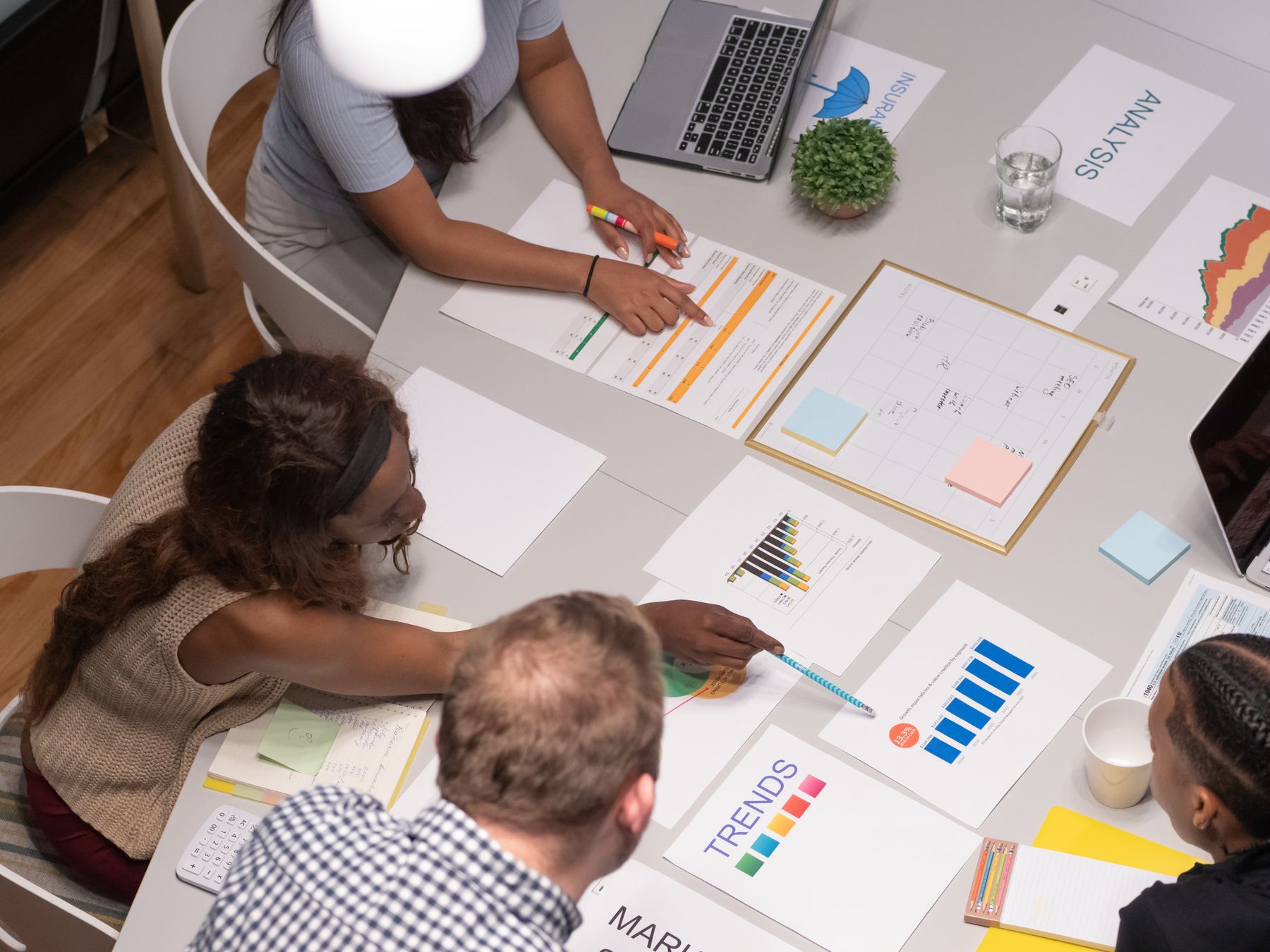Leaders planning around a table covered with documents and charts